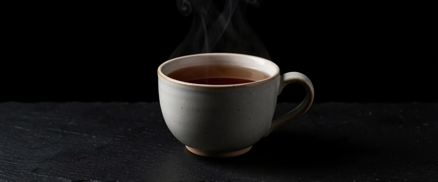 Tazza di tè con vapore su sfondo scuro
